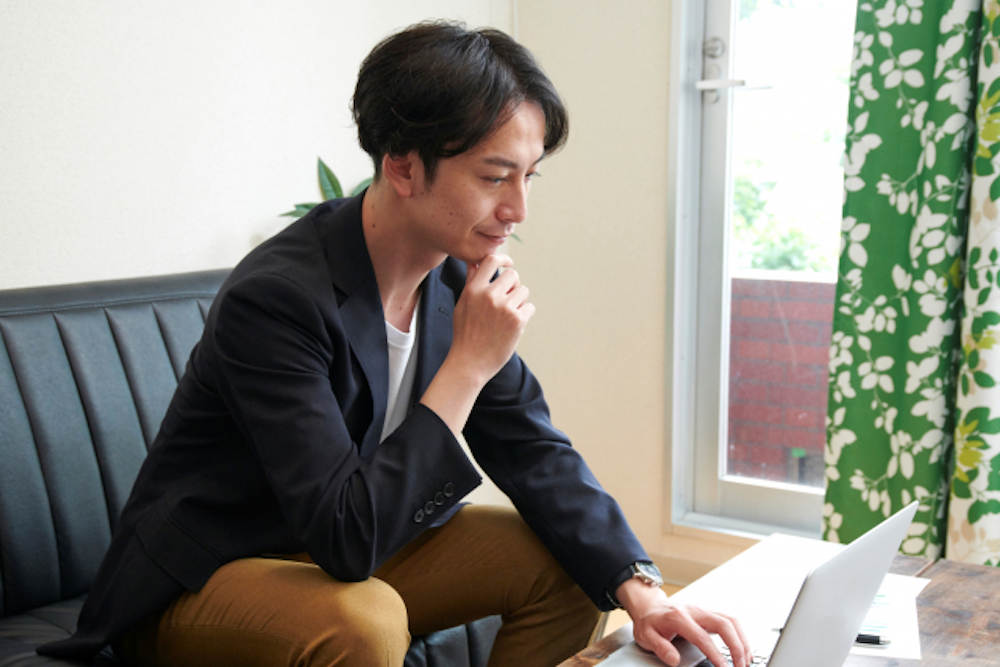 部屋でノートパソコンを操作するビジネスパーソン